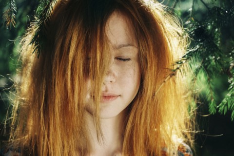 Close up of Caucasian teenage girl near pine tree