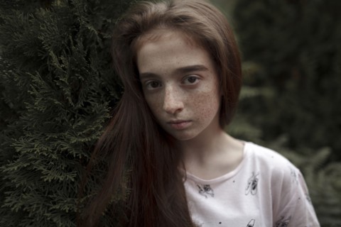 Portrait of serious Caucasian girl with freckles