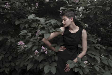 Caucasian woman near flowering tree with hand on hip