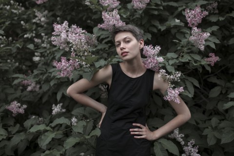 Caucasian woman near flowering tree with hands on hips