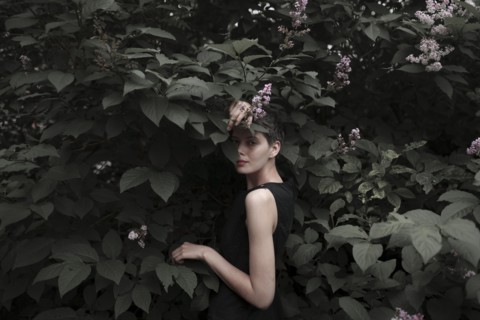 Shy Caucasian woman standing in flowering tree