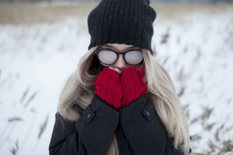 Cold Asian girl wearing a hat and eyeglasses in winter
