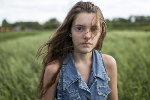 Wind blowing hair of Caucasian woman in field