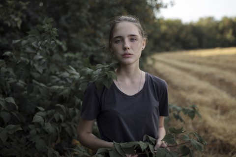 Portrait of Caucasian teenage girl holding branch