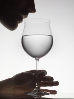 Man drinking water from wine glass