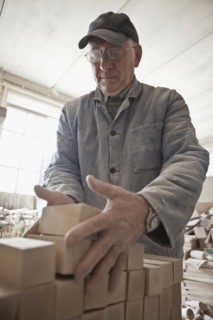 Carpenter stacking wood in woodshop