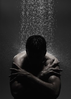 Caucasian man sitting in shower