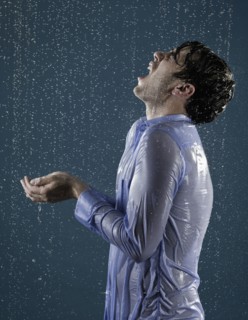 Caucasian man taking a shower in clothing