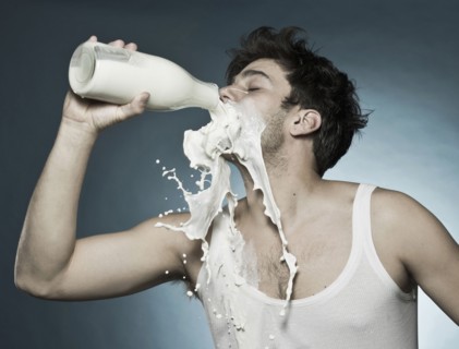 Caucasian man drinking milk and spilling it