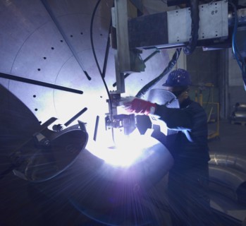 Caucasian worker working on steel pipe in factory