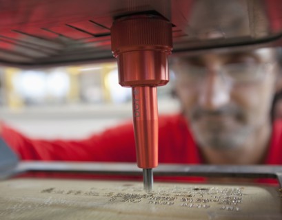 Caucasian worker using branding machine in factory