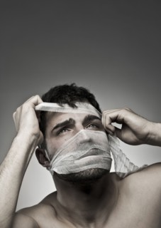 Man removing bandage from his face