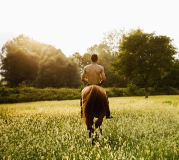 Caucasian man riding horse in field
