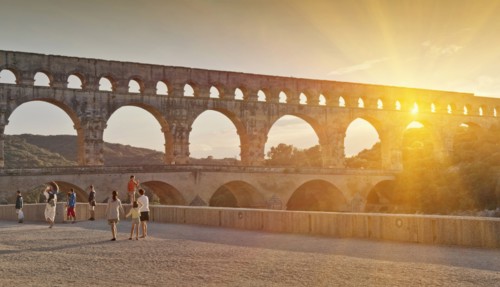 People sightseeing near aqueduct