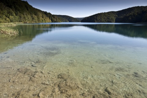 Hills and sky reflected in still lake