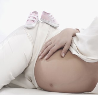 Caucasian woman holding pregnant belly