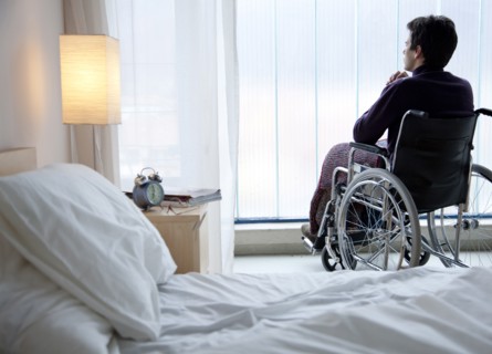Pensive Caucasian man in wheelchair by window