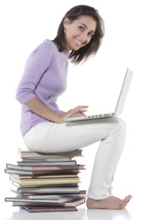 Woman using laptop on stack of books