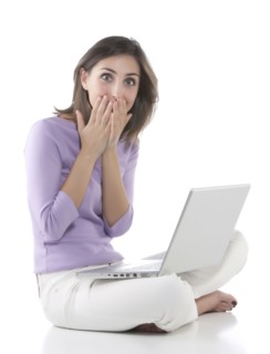 Gasping woman using laptop