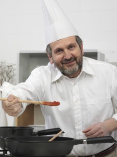 Chef offering taste of food in kitchen
