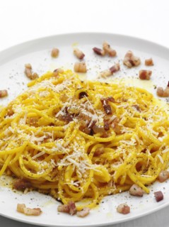 Close up of pasta with bacon bits and cheese