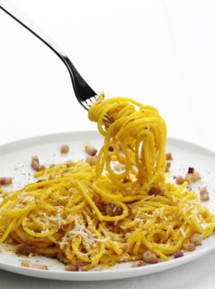 Close up of pasta with bacon bits and cheese