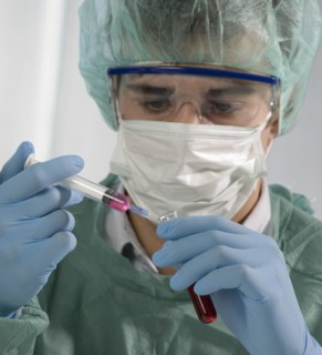 Caucasian scientist holding syringe and test tube
