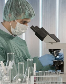 Caucasian scientist using microscope in laboratory