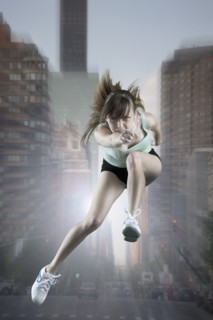 Caucasian woman running and jumping in city