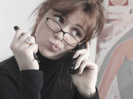 Caucasian businesswoman talking on telephone making a face