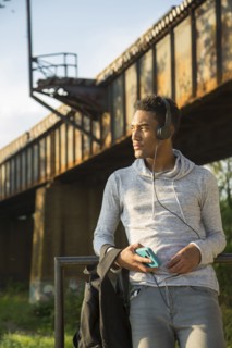 Mixed Race man with backpack listening to headphones