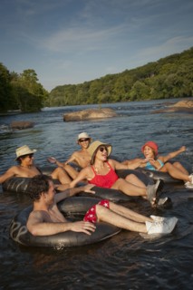 Friends floating on river in inner tubes