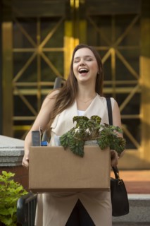 Laughing Caucasian carrying box with potted plant