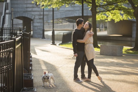 Caucasian couple with dog hugging in park