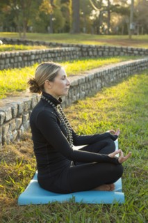 Caucasian woman meditating in park