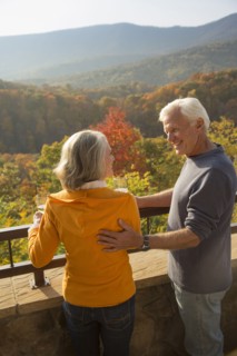 Older Caucasian couple enjoying wine and scenic view