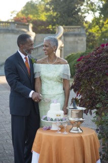 Black couple cutting wedding cake
