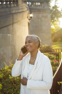Black woman talking on cell phone near stone staircase