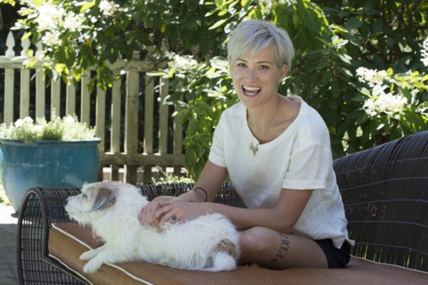 Smiling Caucasian woman petting dog on sofa outdoors