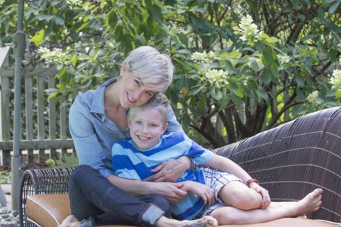 Caucasian woman hugging son on sofa outdoors