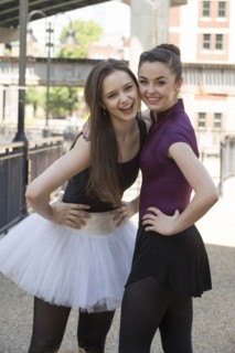 Portrait of smiling Caucasian ballerinas standing outdoors