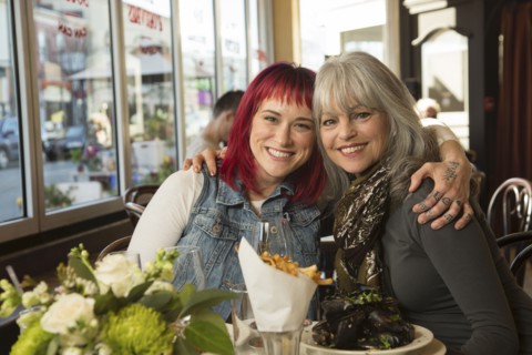 Caucasian women hugging in restaurant