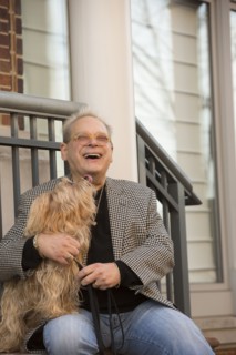 Portrait of Caucasian man sitting on stoop holding dog