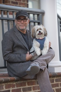 Portrait of Caucasian man sitting on stoop posing with dog