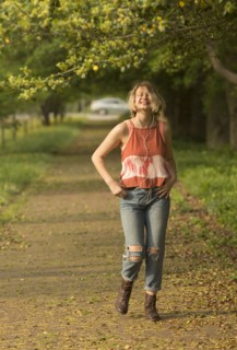 Caucasian girl walking in park listening to earbuds