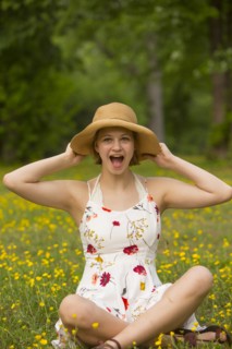 Surprised Caucasian teenage girl sitting in field of flowers