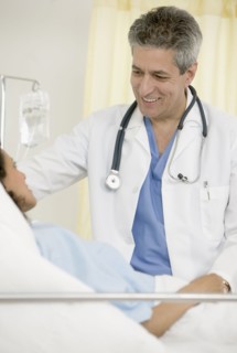 Male doctor talking to female patient in hospital