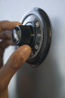 Close up of fingers turning combination lock