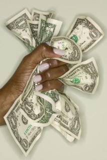 Close up of hands squeezing dollar bills