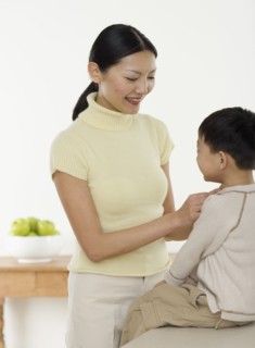 Mother dressing son